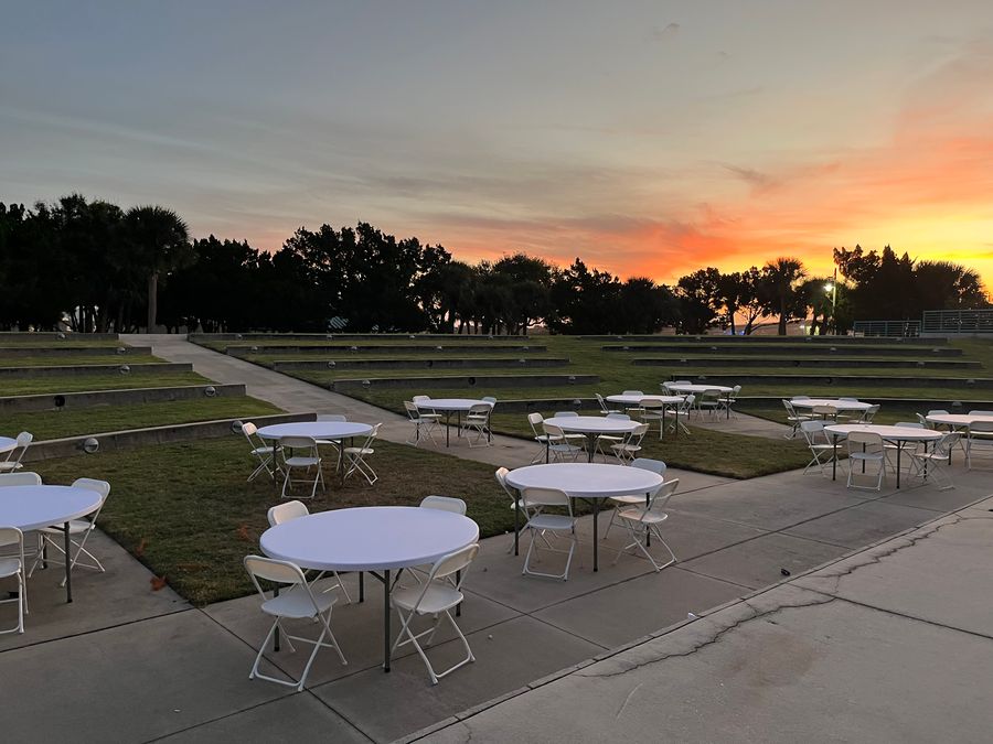 Round dining tables arranged for a reception.
